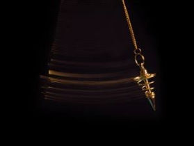 un pendule divinatoire en métal suspendu sur un fond noir