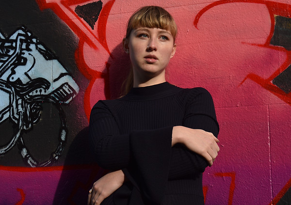 portrait of Zoe Sim with pink colourful graffiti wall