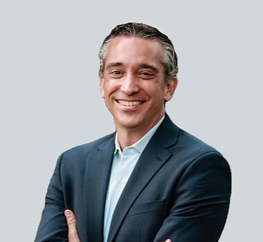 Chris Wells, smiling headshot, dark gray suit