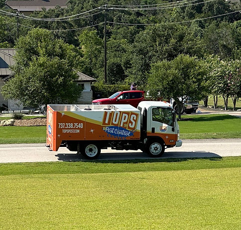 TOPS Pest Control truck parked in street in Austin