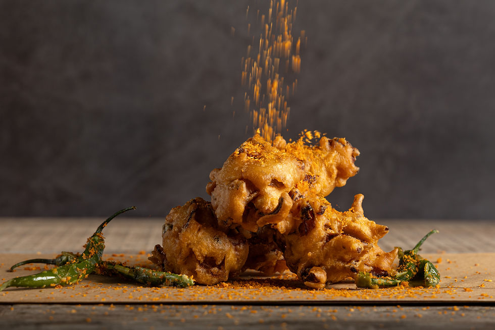 Eye-level view of a plate with crispy onion bhajis and dipping sauces