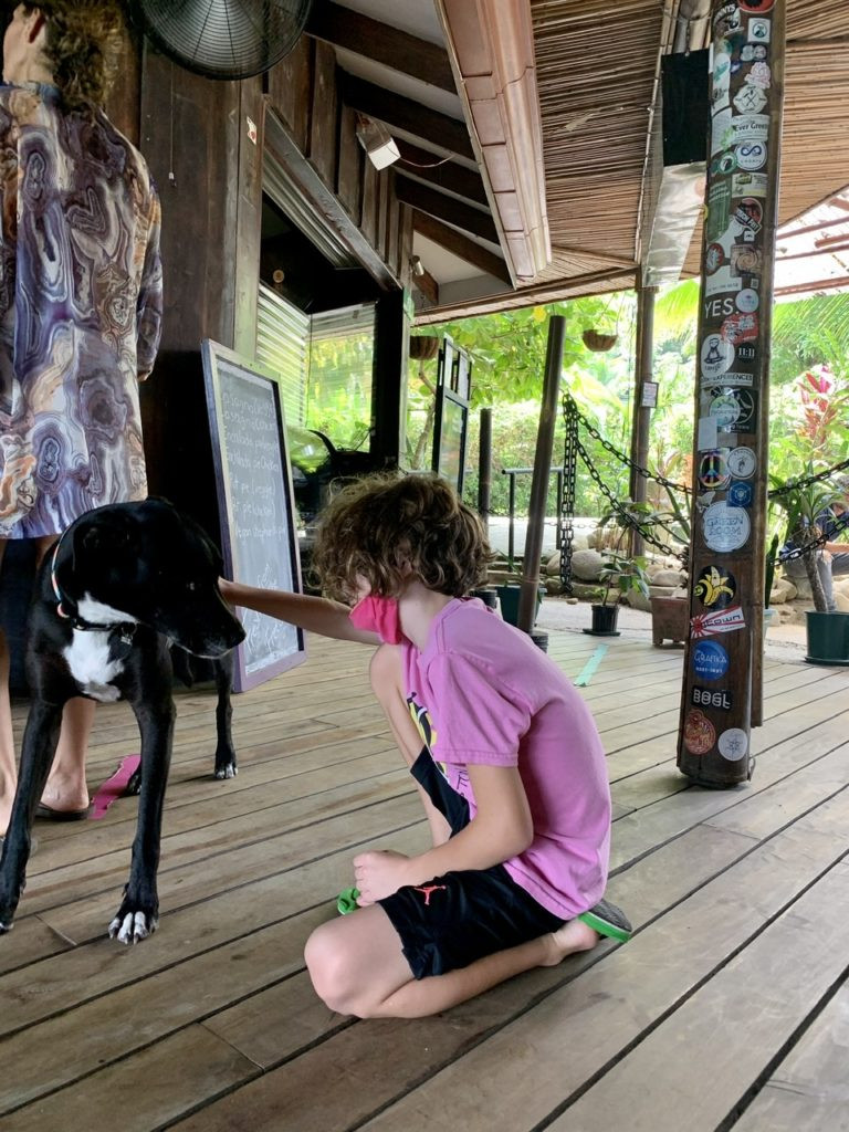 Boy and dog in rainforest cafe costa rica