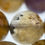 Thumbnail: Polished 12mm round beads of African ametrine with distinctive goethite patterns