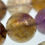 Thumbnail: High-quality 12mm round beads of African ametrine with goethite, known for their smooth finish and color variation.