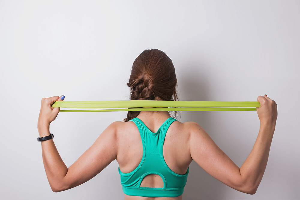 Woman stretching her shoulders with resistance band