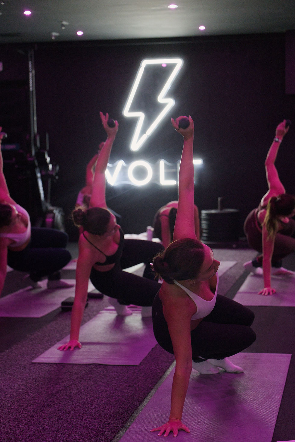 pilates class with women holding poses and dumbbells