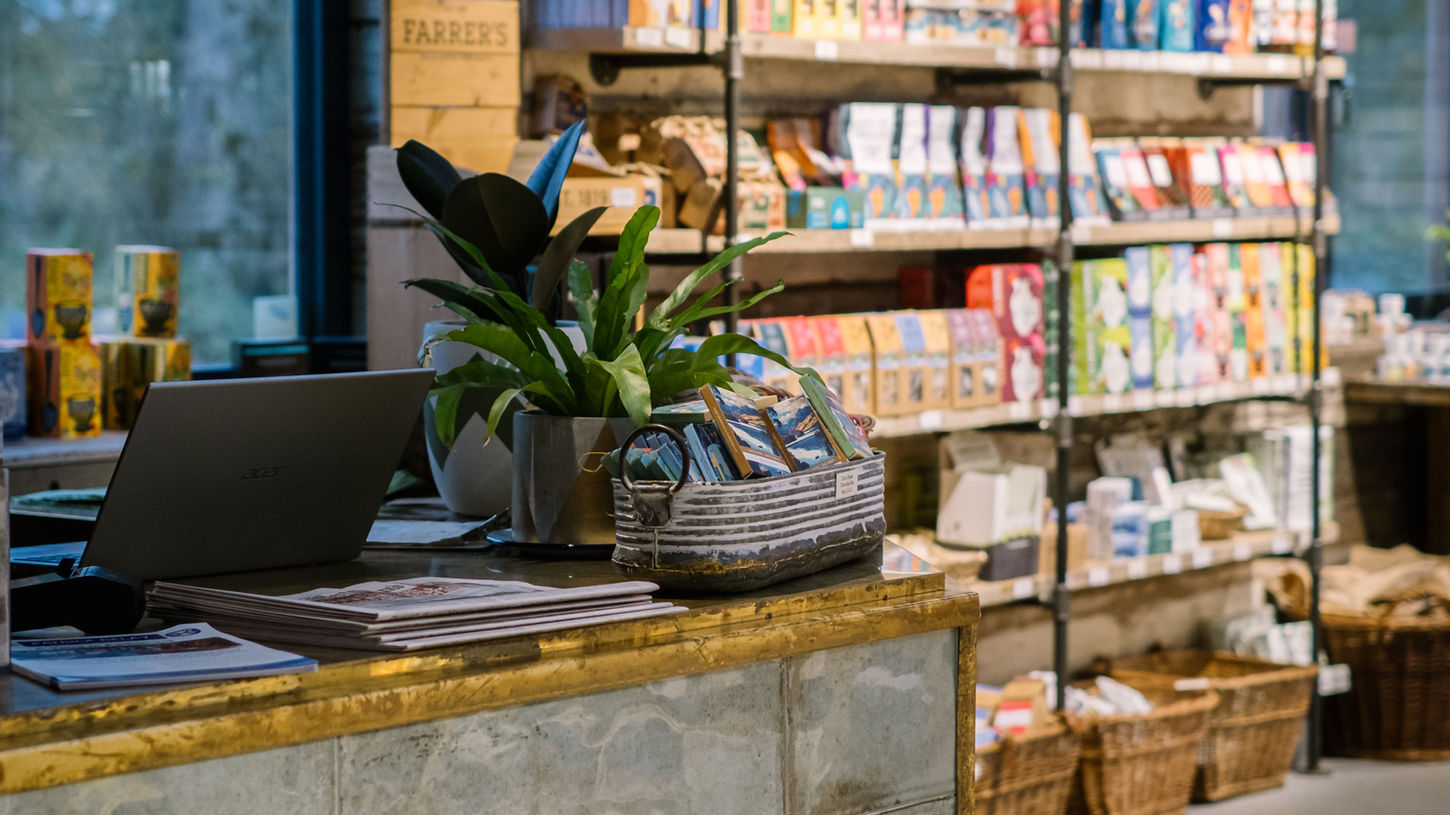 Lifestyle products on shelving behind customer till service area at Basecamp North Lakes farm shop