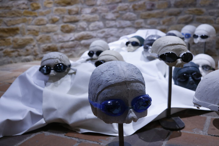 Installation "Nager en eaux troubles" présentée lors de la résidence artistique de Gleizé, représentant des têtes de nageurs pour parler des changements environnementaux à travers le phénomène symbolique de la montée des eaux.