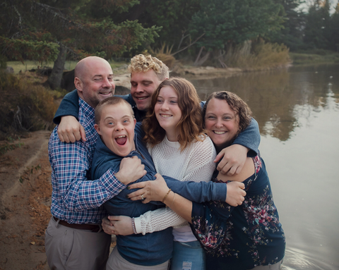 A family with older children have a group hug for a family photo in Lake Placid NY