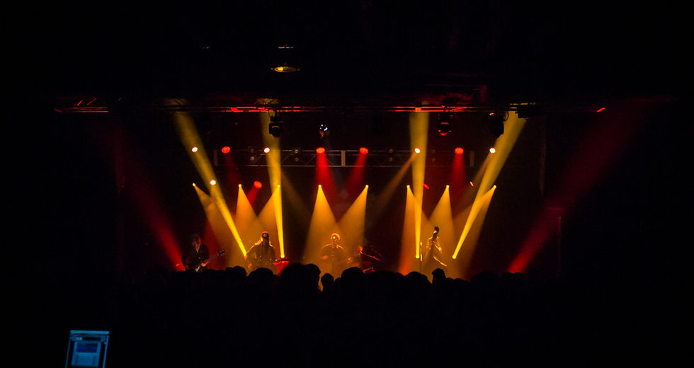 The Devil Makes Three blue grass band live on stage with yellow and red streamed spot ligh