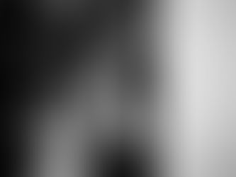 A bride and groom laugh during the cake cutting at their wedding reception