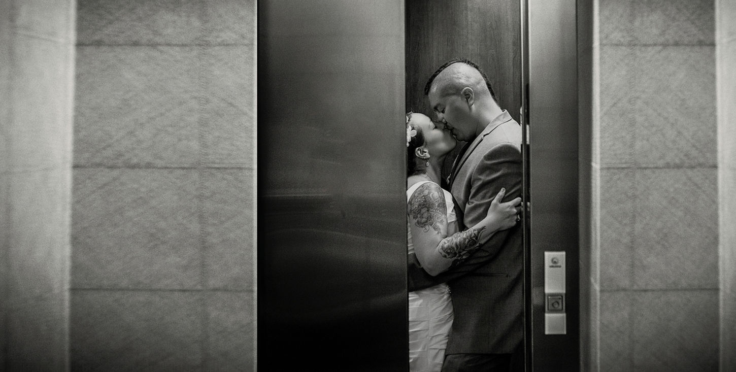 Professional wedding photographer captures a portrait of the bride and groom kissing in a hotel elevator in Plattsburgh, NY.