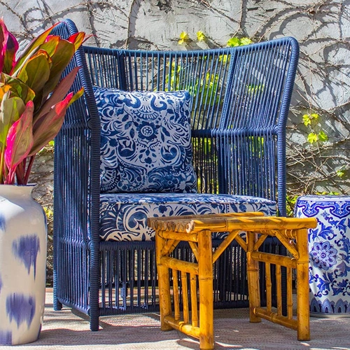 Miniatura: Cadeira de vime azul com almofadas estampadas e banquinho de bambu.