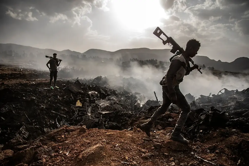 Fighters from a rebel group survey the burning wreckage of an Ethiopian Air Force plane downed in Ethiopia’s northern Tigray region in 2021. Finbarr O'Reilly for The New York Times