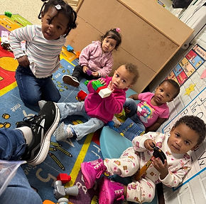 Young children on the carpet playing.