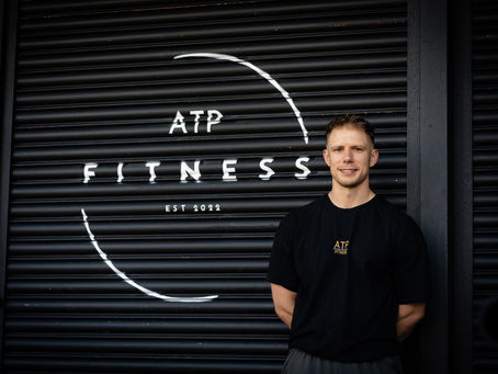 gym owner standing next to logo