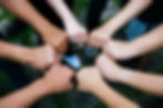 Close up of students standing hands making fist bump gesture