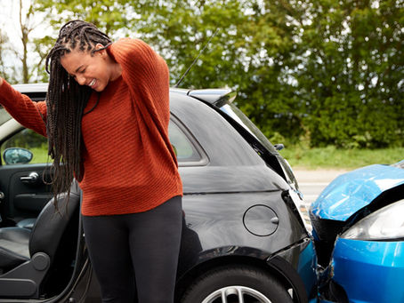 A woman grabbing her neck in pain after a fender bender