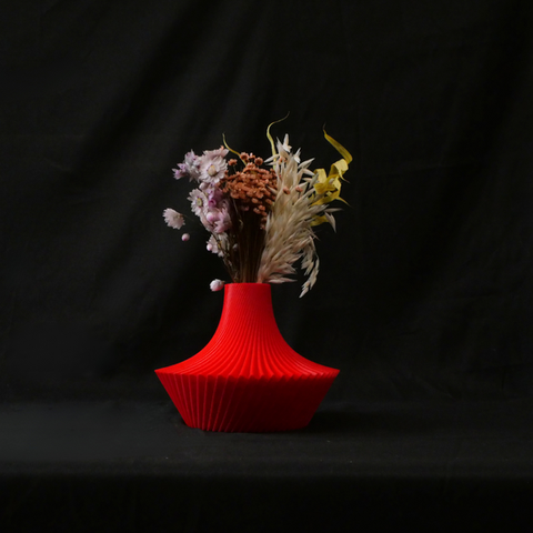 red flower vase with flowers in it