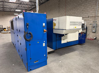 Blue and white industrial laser cutting machine in a factory.