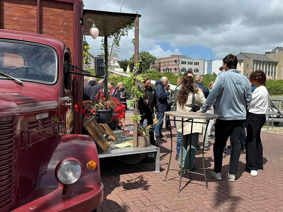 People stand outside a foodtruck eating and drinking