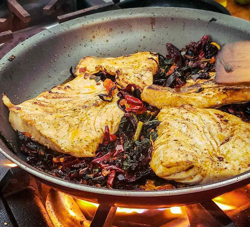 Delicious Mexican food simmers in a frying pan.