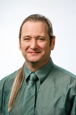 Joshua Whitley smiles and wears a green tie