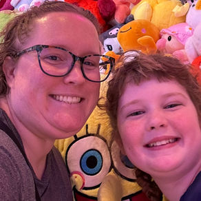 mother and daughter in front of a wall of toys
