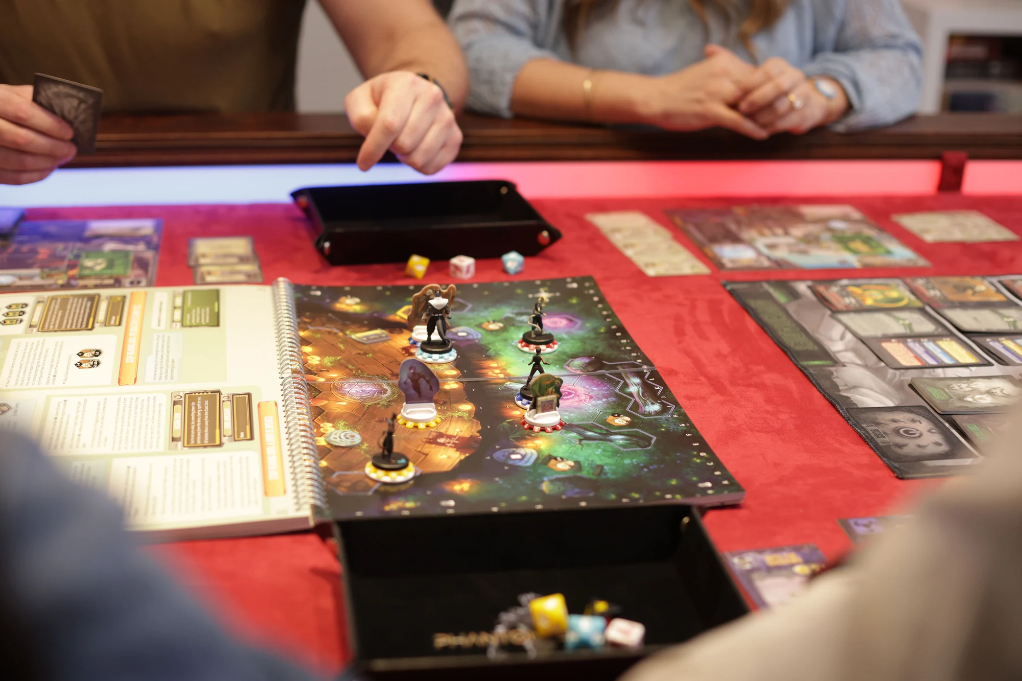 Players gathered around a Phantom Epoch mission, with character boards and Action cards on the table