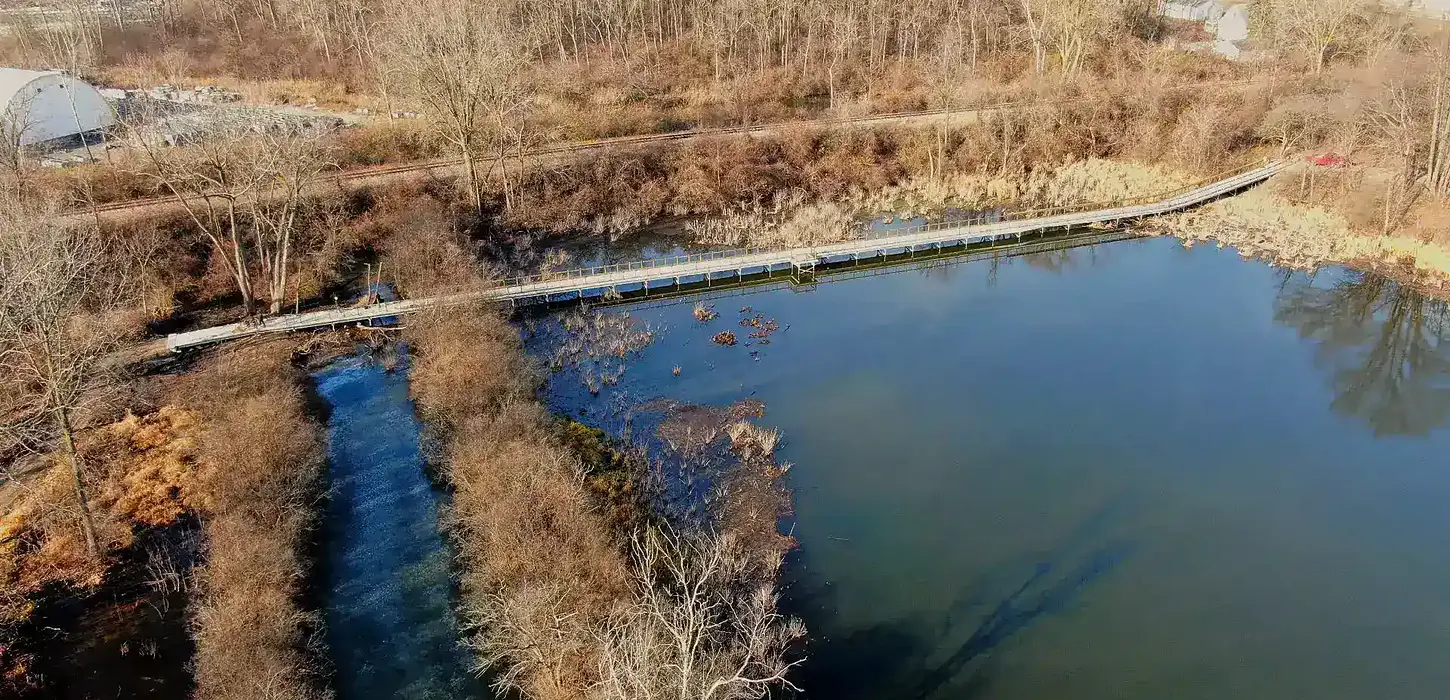 Terratread precast concrete boardwalk park feature crossing over pond and surrounding wildlife area.