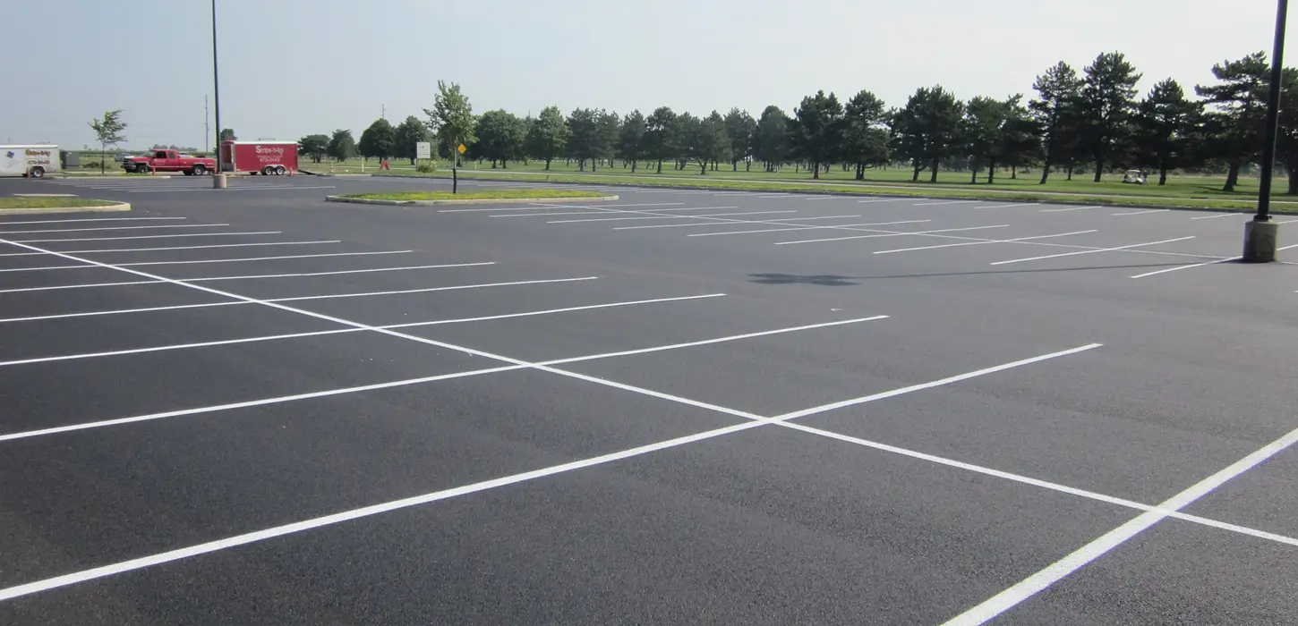 New lighted asphalt parking lot with raised islands, new paint markings.