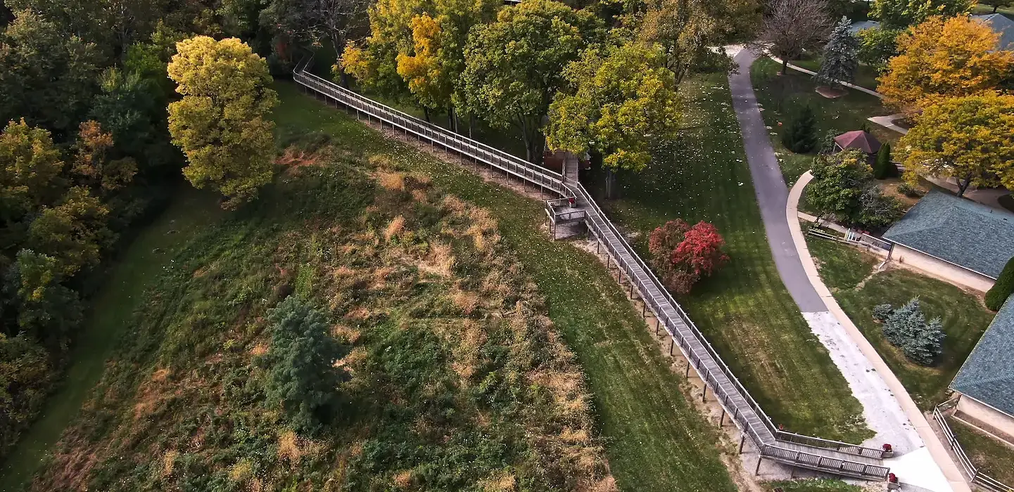 Aerial view of finished boardwalk. There are colorful trees in the background.