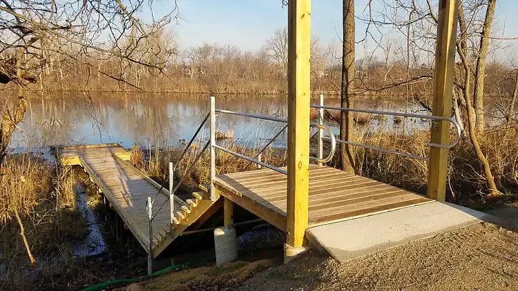 Wood boardwalk park feature and descending stairs leads down to wildlife area.