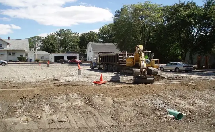 Active parking lot construction site with heavy equipment.