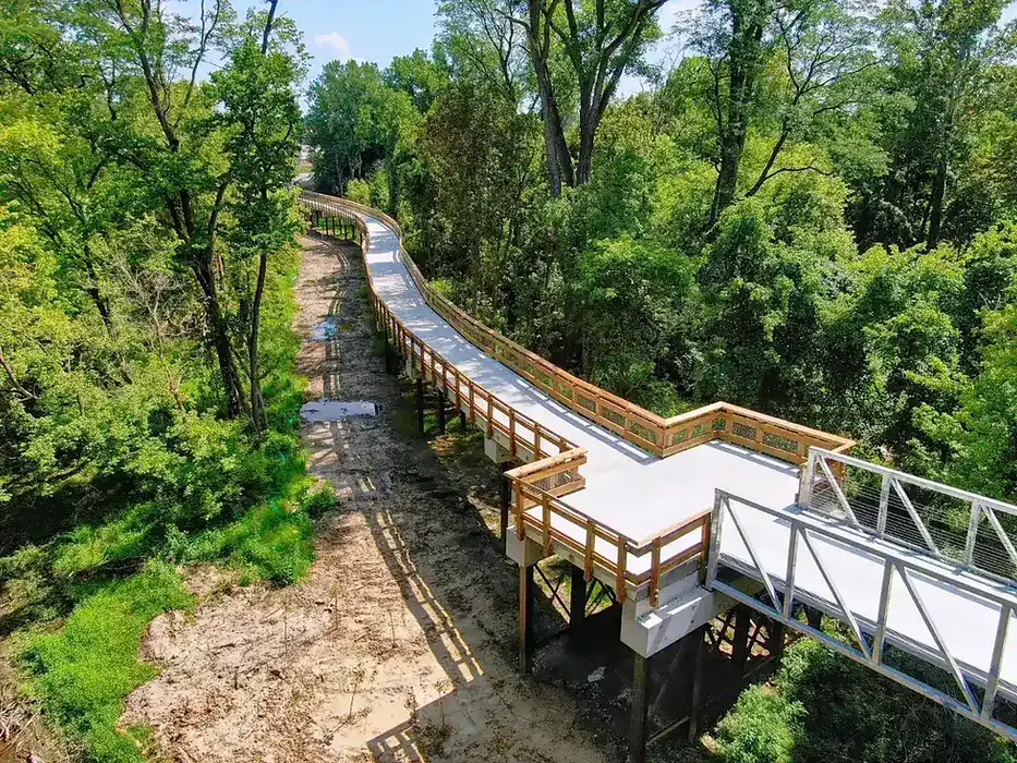 Aerial view of connector trail at Swan Creek Park. There are trees in the background.