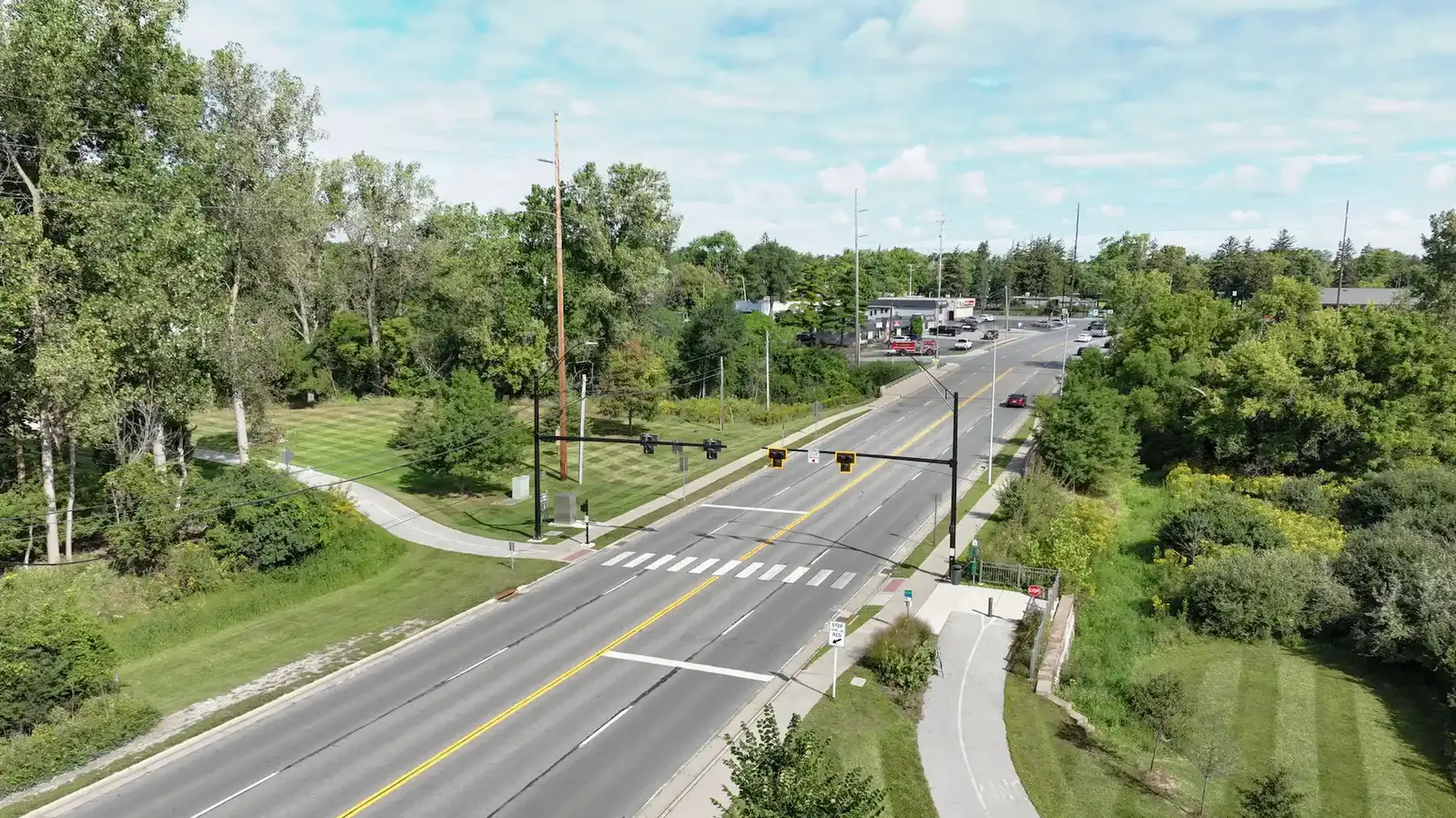 Aerial view of four-lane road featuring crosswalk for pedestrians on the trail.