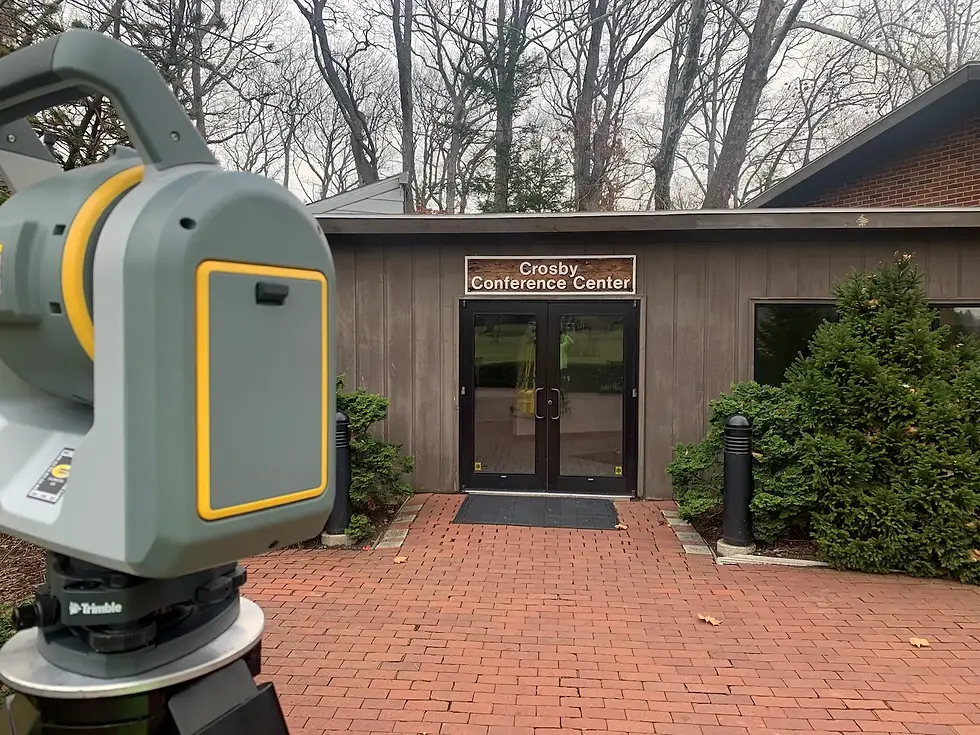 Land surveyor's trimble scanner and a park building facade and handscaped entrance.