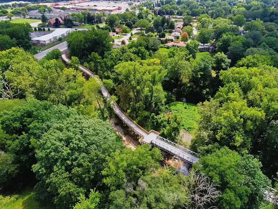 Aerial view of connector trail at Swan Creek Park. There are trees in the background.