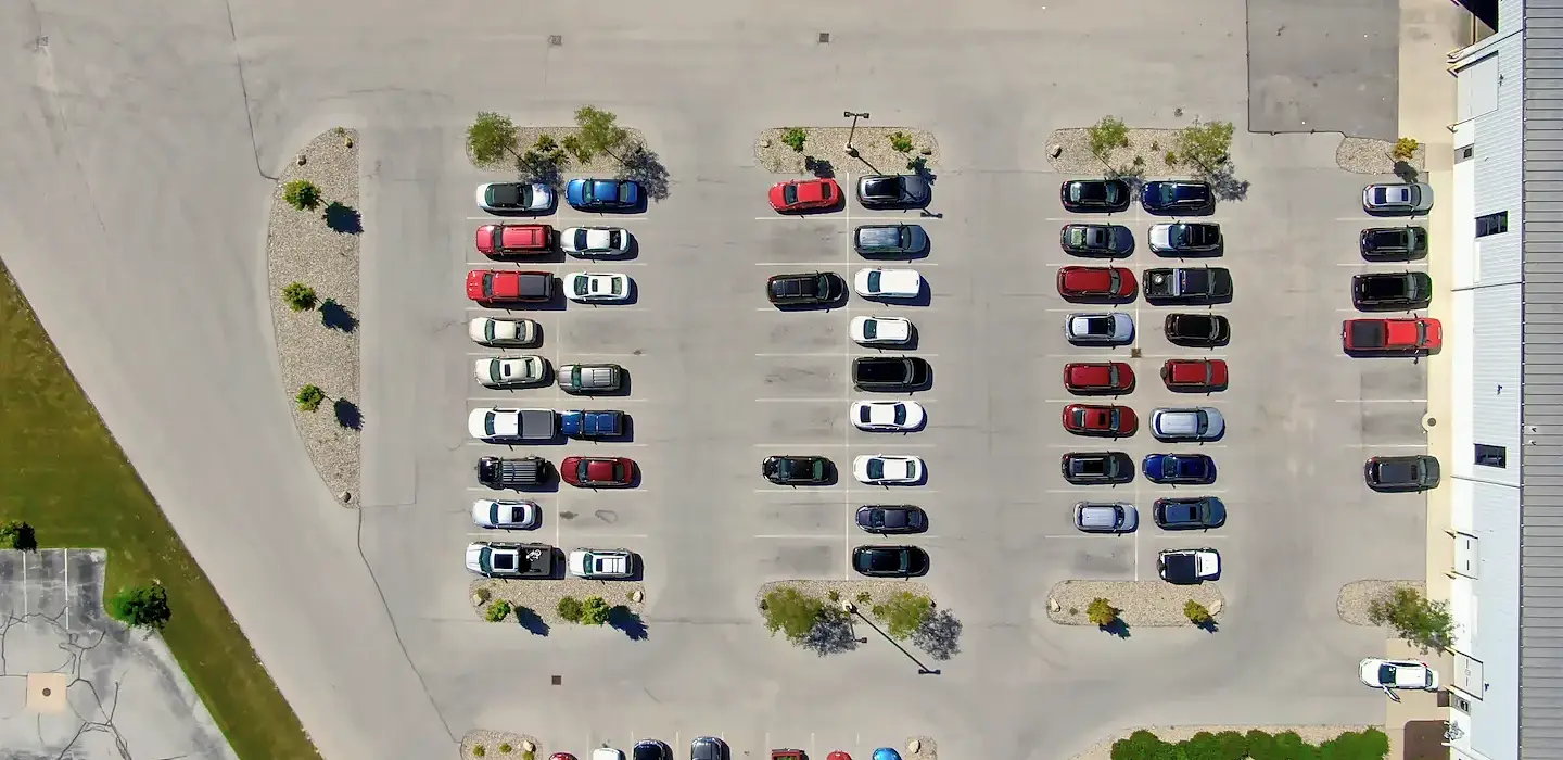 Aerial view of an improved and expanded parking facilities full of cars.