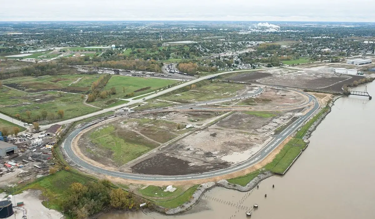 Aerial photo of an industrial site and the surrounding area next to a river. 