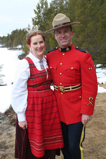 Eit kanadisk brurpar, der mannen er i kanadisk politiuniform og brura i rondastakk og med krone.