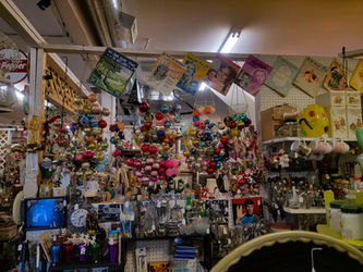 An antique store books with a variety of items lining it from floor to ceiling, including magazines and Christmas ornaments.