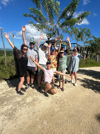 A group of people smiling in front of a jeep