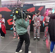 Cameraman in front of a couple Batala members in costume at BBC Breakfast for Kevin Sinfield 7in7in7 Dec 2024
