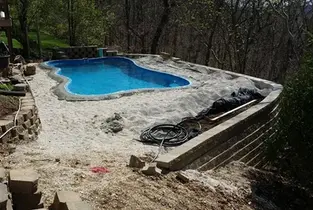 Luxury gunite pool in St. Louis backyard with large retaining wall.