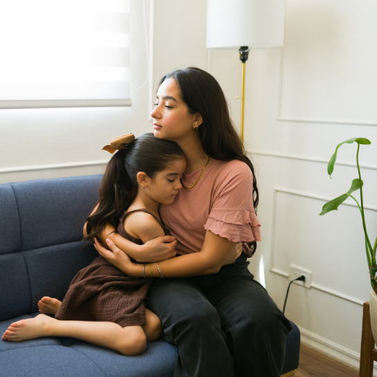 Sick kid hugging her mom feeling ill and sad