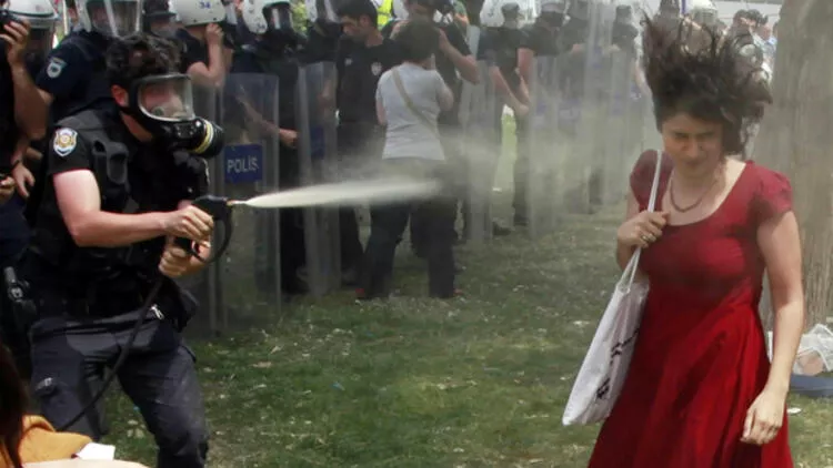 Gezi Parkı eylemlerinde "Kırmızılı kadın" olarak tanınan Ceyda Sungur'a, biber gazı sıkan polis memuru.