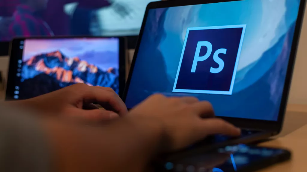 Fotoğrafçı, dizüstü bilgisayarı ile Photoshop uygulamasını açıyor.