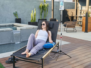 Relaxed professional taking a mindful break with water and healthy snacks in a bright Los Angeles home, representing recovery, hydration, and wellness after a busy week.