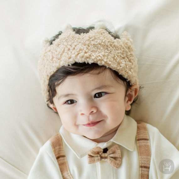 Thumbnail: The Rence Crown Baby Hairband features a delightful pom-pom at the front and a Velcro tape at the back for an adjustable fit,